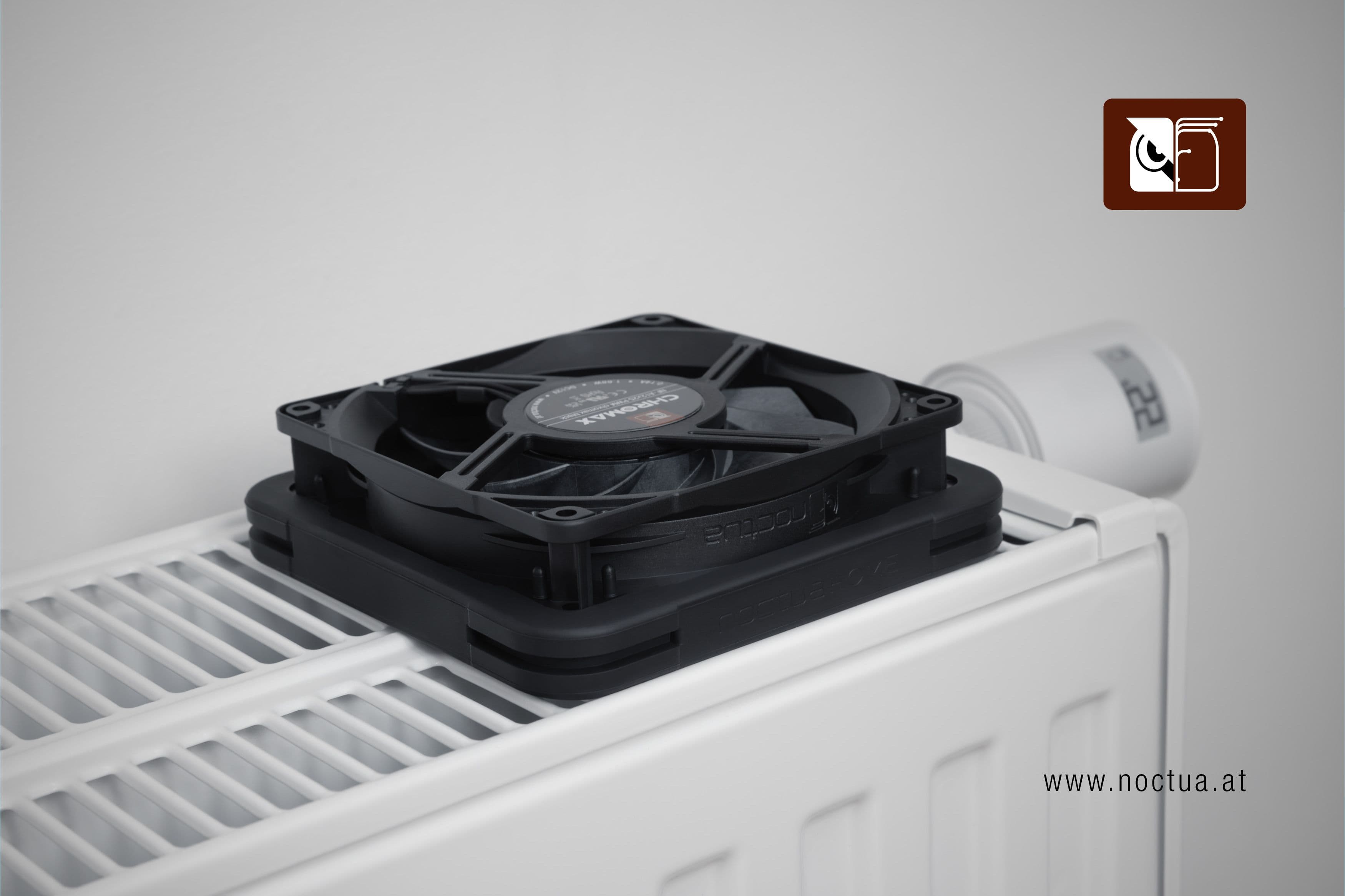 Noctua NF-A12x25 chromax.black fan equipped with NV-MPG1 gasket placed on a household radiator, demonstrating active radiator ventilation.