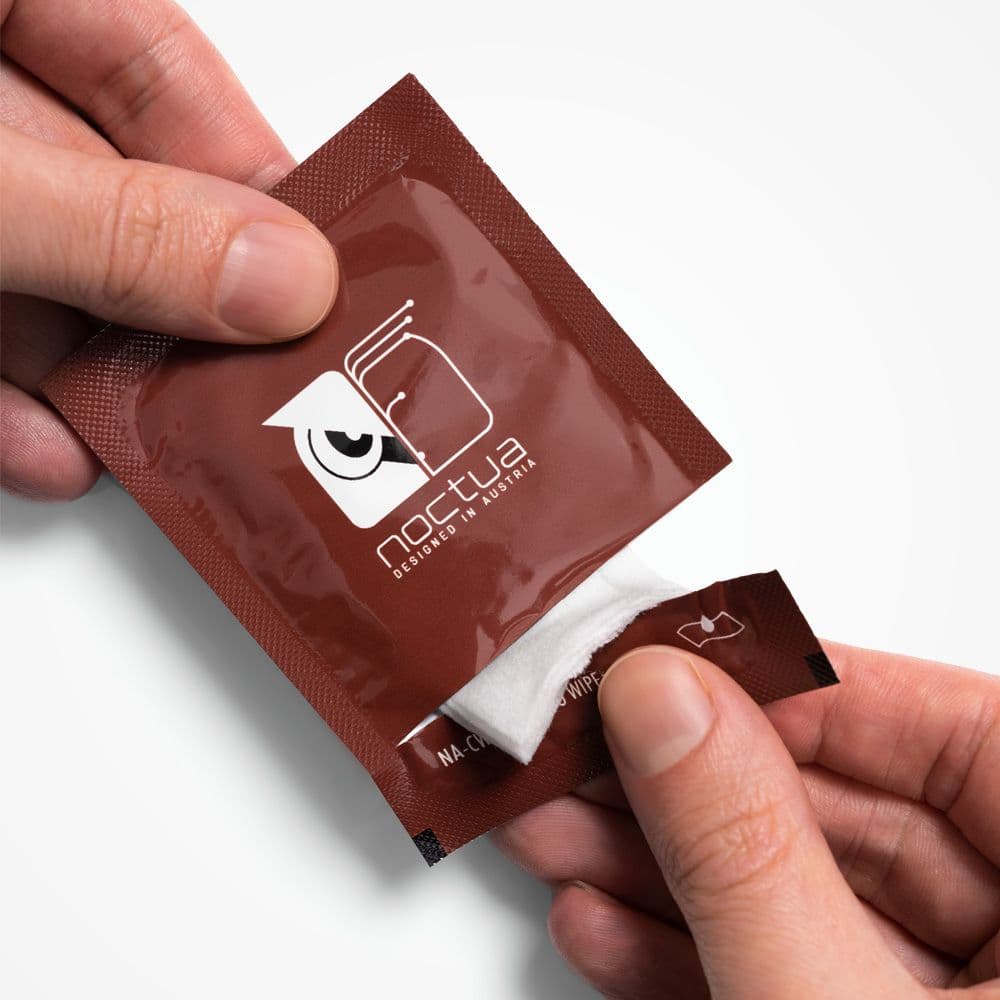 A pair of hands opening a brown foil packet for a Noctua NA-CW1 thermal paste cleaning wipe.