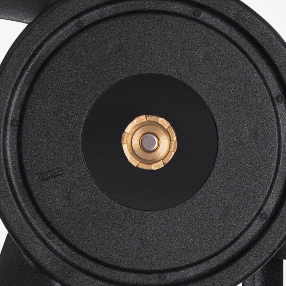 A close-up of the central brass bearing in a matte black Noctua fan hub, showing its textured, gear-like surface design.