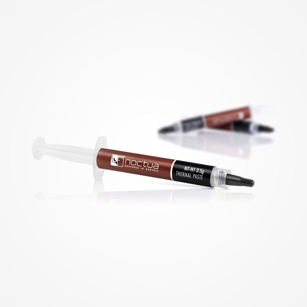An angled shot of a syringe of Noctua NT-H1 3.5g thermal paste on a reflective white surface, with two syringes in the background.