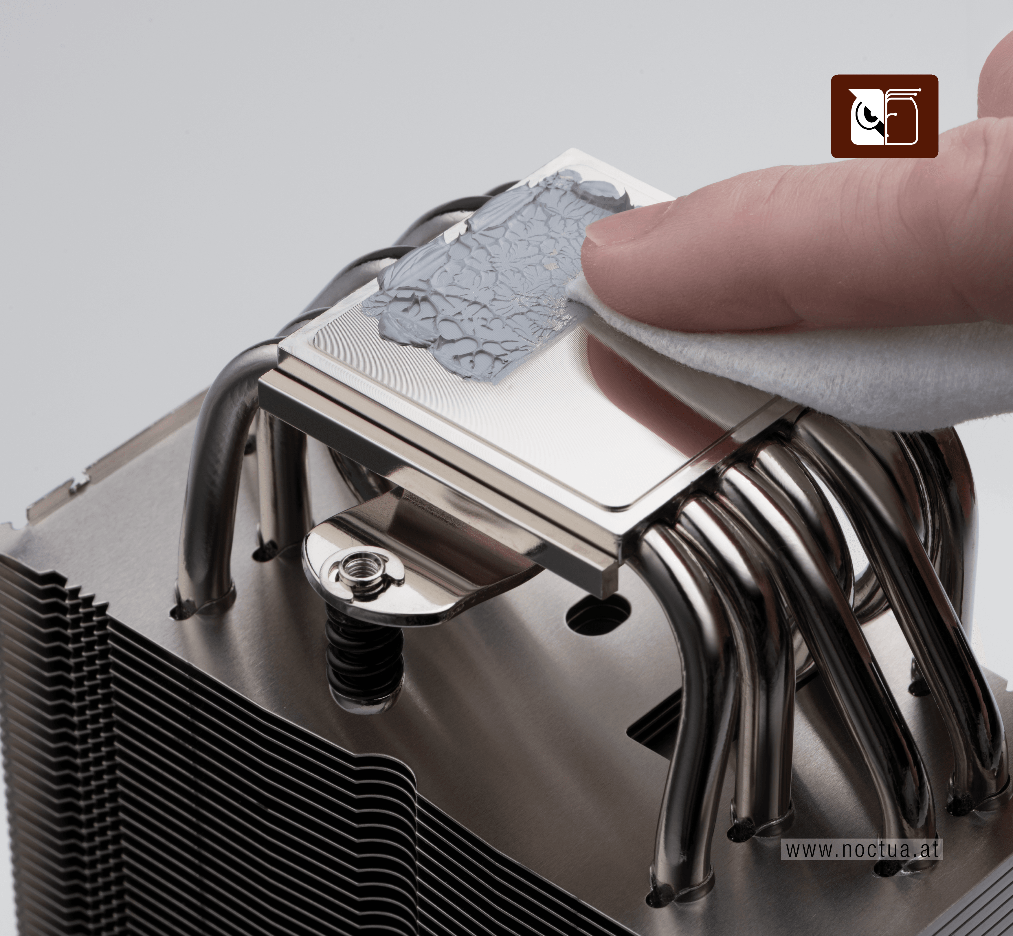 A cleaning wipe is used to remove thermal paste from a cooler base